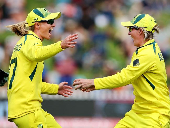 Australia's Beth Mooney (R) celebrates with teammate captain Meg Lanning (L) after catching out New Zealand's Amelia Kerr during the 2022 Women's Cricket World Cup match between New Zealand and Australia at the Basin reserve in Wellington on March 13, 2022. (Photo by Marty MELVILLE / AFP)