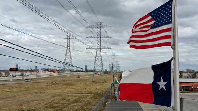 HOUSTON, TEXAS - FEBRUARY 21: The US and Texas flags fly in front of high voltage transmission towers. Last month millions of Texans lost power when winter storm Uri hit the state and knocked out coal, natural gas and nuclear plants that were unprepared for the freezing temperatures brought on by the storm. Picture: Getty Images