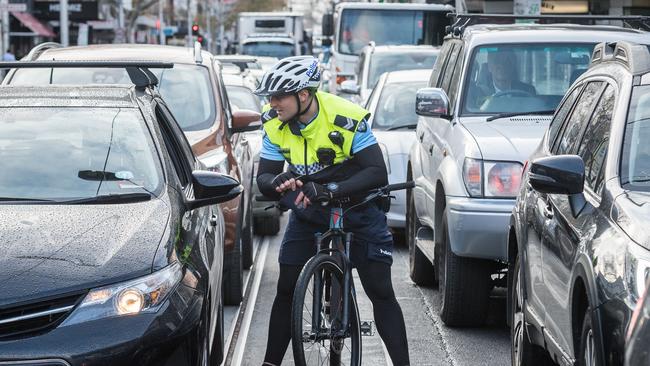 Senior Constable Ben McDonald books a driver for using their phone while driving. Picture: Jake Nowakowski