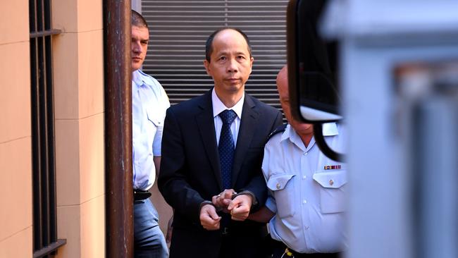 Robert Xie (left) is escorted to a prison transport vehicle at the NSW Supreme Court in Sydney in February 2017 after he was found guilty of murdering five members of his wife's family in the bedrooms of their North Epping home. (AAP Image/Paul Miller)