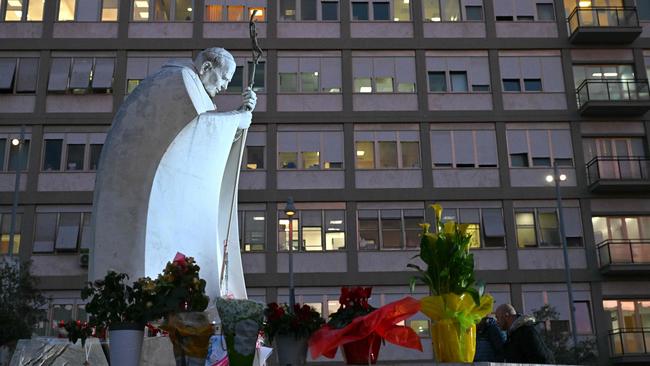 Flowers are laid at the statue of John Paul II outside the Gemelli University Hospital where Pope Francis is hospitalised with pneumonia, in Rome.