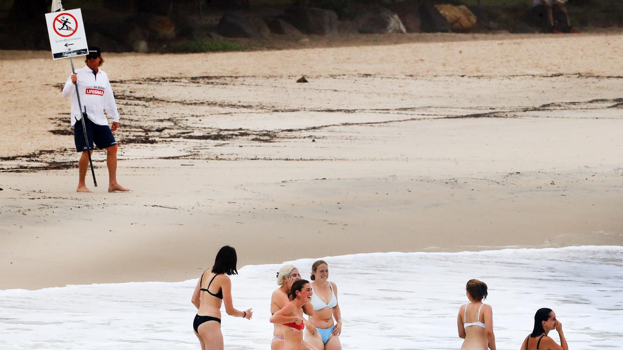 A Gold Coast City Line Guard watches swimmers at Burleigh Beach as wet weather descended over the Gold Coast. Photo: Scott PowickNEWSCORP