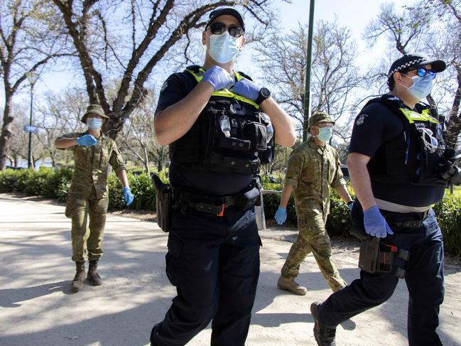 Police officers and army personnel patrol the Tan Track during stage 4 lockdowns in Melbourne. The stringent restrictions were due to end on September 13 but are being extended for a further two weeks. Picture: NCA NewsWire / David Geraghty