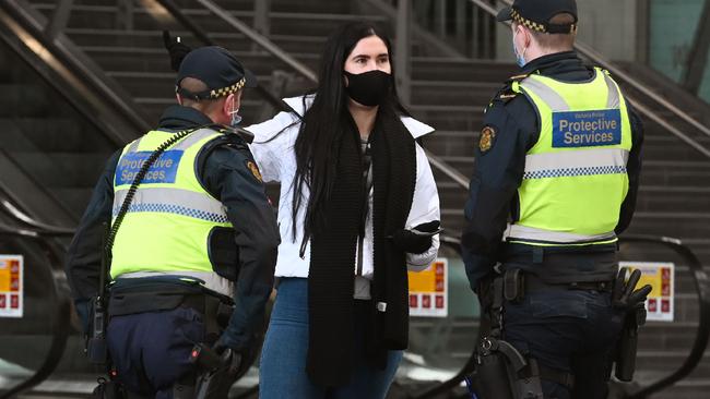 Protective services officers speak to a woman at Southern Cross station. Picture: William West/AFP