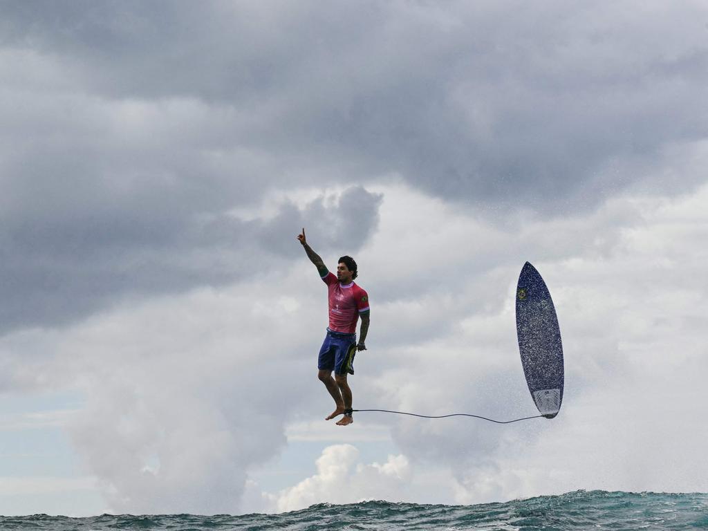 <p>It may look like it&rsquo;s part of the wave of AI-altered images but this shot is all real, with Brazil's Gabriel Medina caught in real time celebrating acatching a large wave in the 5th heat of the men's surfing round 3, during the Paris 2024 Olympic Games, in Teahupo'o, on the French Polynesian Island of Tahiti in July. Picture: Jerome Broilett/AFP</p>