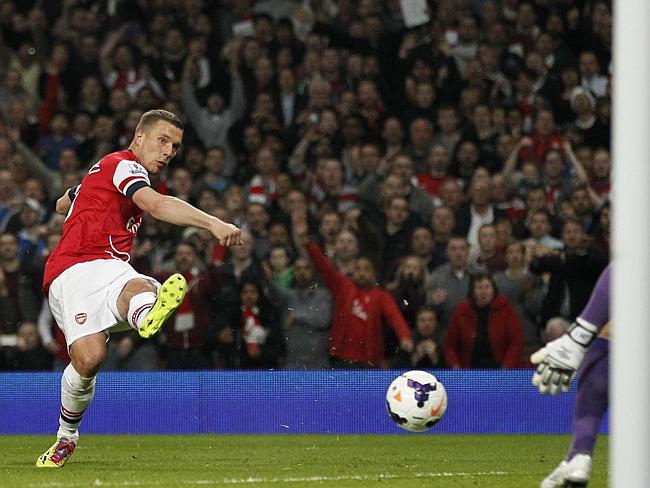 Arsenal's Lukas Podolski has a shot at goal saved by Manchester City's Joe Hart.