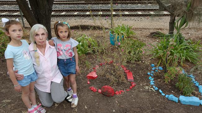 Paula Halliwell with Ella, 8, and Shira, 5, outside her Port Melbourne home with all that remains of her fairy garden. Picture: Ian Currie