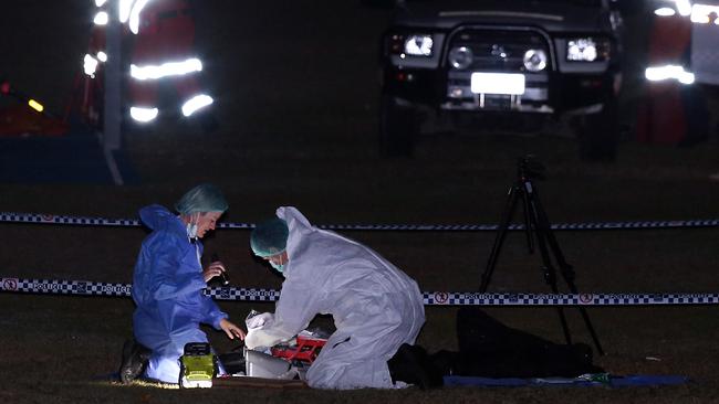 Photo of police at the scene with SES searchers in the background. AAP Image/Richard Gosling.