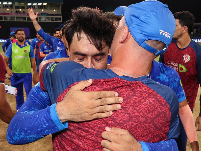 ST VINCENT, SAINT VINCENT AND THE GRENADINES - JUNE 24: Rashid Khan of Afghanistan embraces Jonathan Trott, Head Coach of Afghanistan after the team's victory and to advance to the Semi Finals in the ICC Men's T20 Cricket World Cup West Indies & USA 2024 Super Eight match between Afghanistan and Bangladesh at Arnos Vale Ground on June 24, 2024 in St Vincent, Saint Vincent and The Grenadines. (Photo by Darrian Traynor-ICC/ICC via Getty Images)