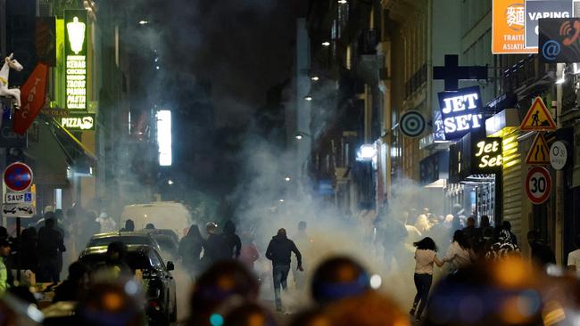 Demonstrators run as French police officers use tear gas in Paris. Picture: AFP