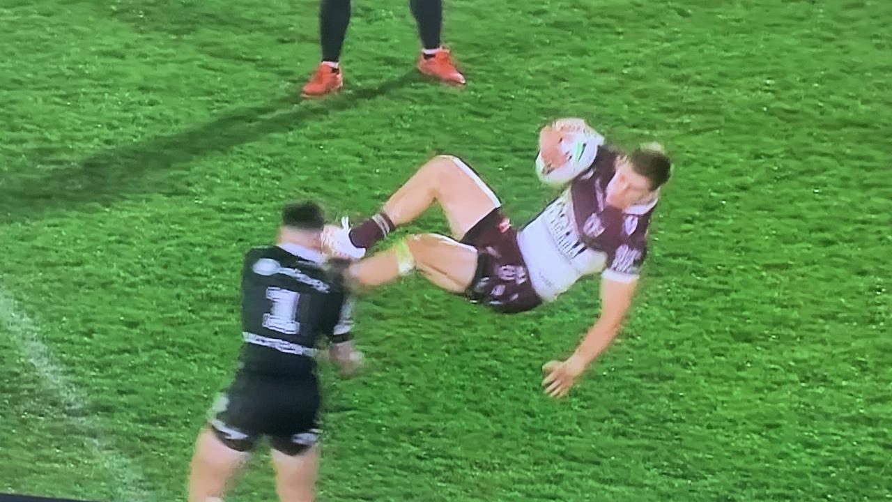 Manly’s Reuben Garrick is tackled in mid-air by NZ Warriors fullback Charnze Nikoll-Klokstad in Auckland last night.