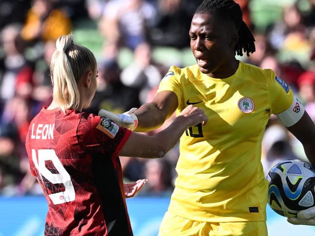 Nigeria's goalkeeper #16 Chiamaka Nnadozie (R) speaks with Canada's forward #19 Adriana Leon during the Australia and New Zealand 2023 Women's World Cup Group B football match between Nigeria and Canada at Melbourne Rectangular Stadium, also known as AAMI Park, in Melbourne on July 21, 2023. (Photo by WILLIAM WEST / AFP)