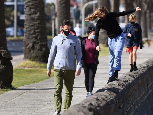 A family exercises along Port Melbourne Beach in Melbourne as the city remains under stage four restrictions. Picture: AFP