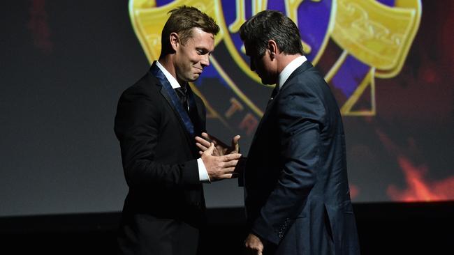 Former Hawthorn player Sam Mitchell (left) is retrospectively awarded the 2012 Brownlow Medal by 1999 Brownlow medallist Shane Crawford in 2016. (AAP Image/Julian Smith)