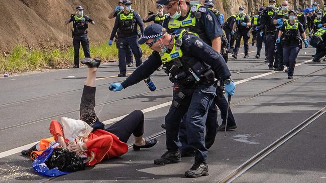 An officer sprays an anti-lockdown protester. Picture: Jason Edwards