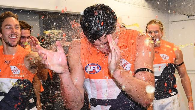 Debutant Jake Stein of the Giants is sprayed with drinks in the rooms after GWS won their round 13 AFL match against North Melbourne in Hobart. Picture: Quinn Rooney/Getty Images