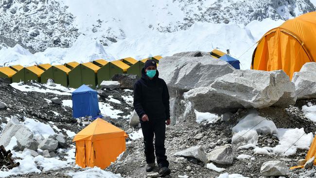 An expedition base camp staff member wearing a facemask walks around Everest base camp, prior to the ban. Picture: AFP