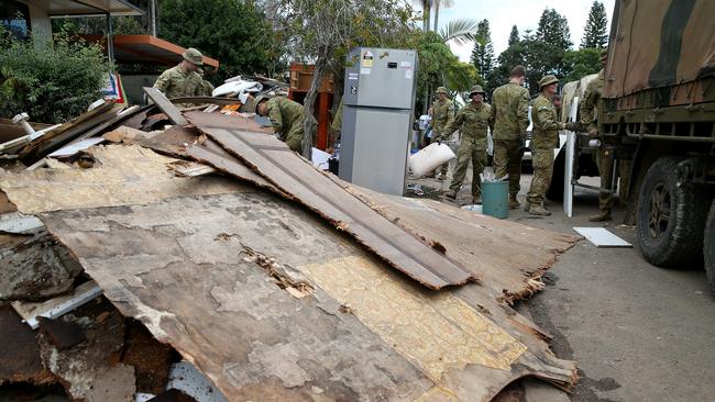 Officers from the ADF 6th Battalion RAR in Brisbane help clean up after the floods. Picture: Nathan Edwards