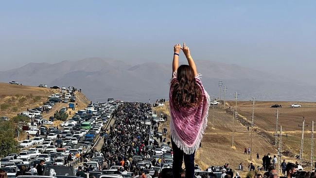 A woman standing on top of a vehicle as thousands make their way towards Aichi cemetery in Saqez, Mahsa Amini's home town in the western Iranian province of Kurdistan, to mark 40 days since her death. Picture: AFP PHOTO / UGC IMAGE