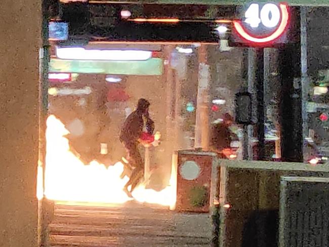 Screen grabs of three men setting fire to the Lux night club in Chapel Street South Yarra.