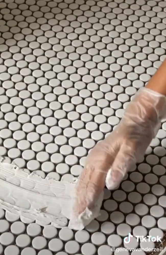 using a pair of gloves, she used her hands to cover it in grout, before wiping it clean with a sponge. Picture: TikTok/genevavanderzeil