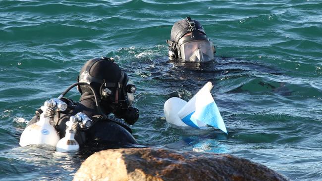 Police divers and friends of the deceased search the Southport Seaway for a weight belt that belonged to the diver that died. Picture Glenn Hampson