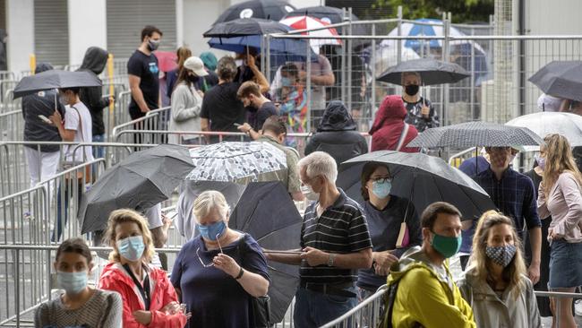 People queue in the rain at the Alfred Hospital Covid testing site on Sunday morning. Picture: NCA NewsWire / David Geraghty