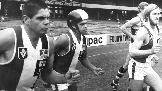 Robert Muir(left) runs on to the MCG with Saints teammates including Phil Narkle.