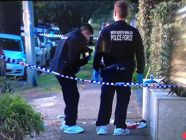 Police photograph a bloody towel outside the Manly Waves apartment complex in Malvern Ave, Manly, on Monday. Picture: 7News