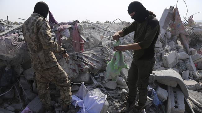 Militants search what is left of Abu Bakr al-Baghdadi’s last redoubt on Monday. Picture: AP