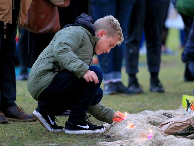 A boy lights a candle at a vigil for Eurydice Dixon. Picture: Mark Stewart