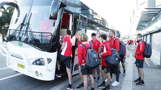 Sydney Swans players get on a bus headed for the airport to fly to Queensland.