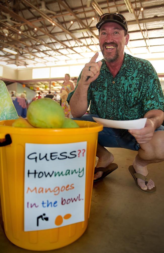 Mike Wharerau has a guess at how many or the fruit fill a bin during a previous Berry Springs Mango Festival. Picture Patrina Malone