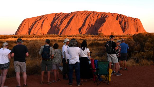 Tourists gather to watch sunset colours on Uluru after a permanent climbing ban was introduced. Picture: Saeed Khan/AFP