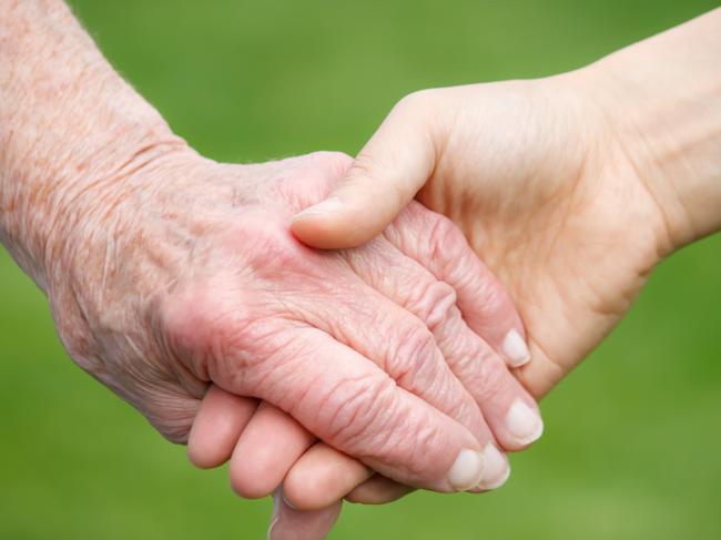 Young woman holding old woman's hand