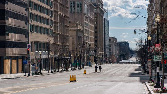 Two police officers walk through empty streets downtown in Washington, DC. Picture: Getty Images