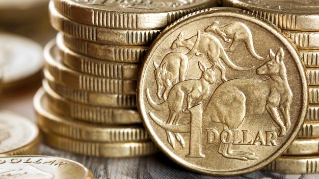 Stacks of Australian one dollar coins. Focus on front coin.