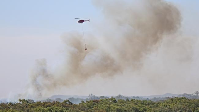 A helicopter waterbombs a fire.