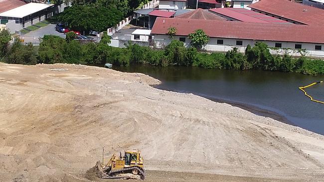 Workers move earth at Black Swan Lake at Bundall, which has almost been filled in. Picture: Glenn Hampson.