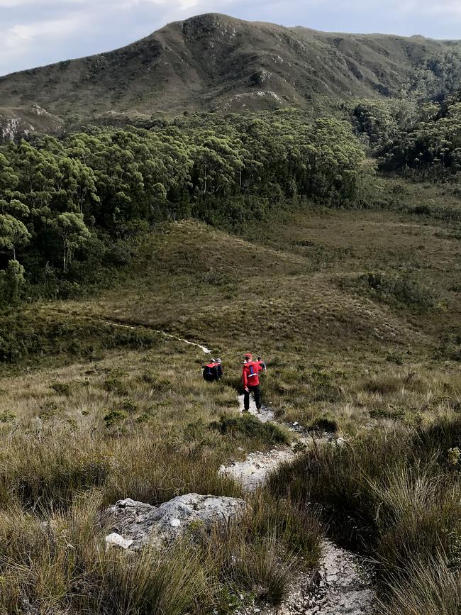 Walkers descend Balmoral Hill in Tasmania's Wilderness World Heritage Area southwest region, Australia, April, 2018. (AAP Image/Candice Marshall)