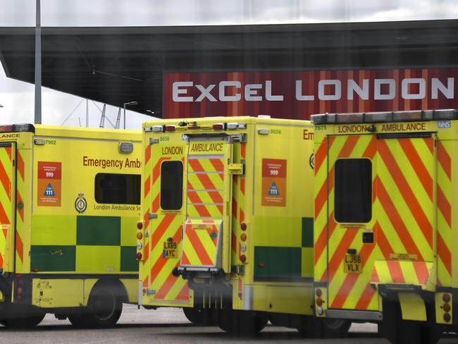 Ambulances parked outside the Excel London centre, that is being prepared to become a temporary National Health Service (NHS) hospital to be called the Nightingale Hospital, in London, Saturday March 28, 2020. The Nightingale Hospital will have two wards, each capable of holding up to 2,000 COVID-19 coronavirus patients when it opens early next week.(AP Photo/Alberto Pezzali)