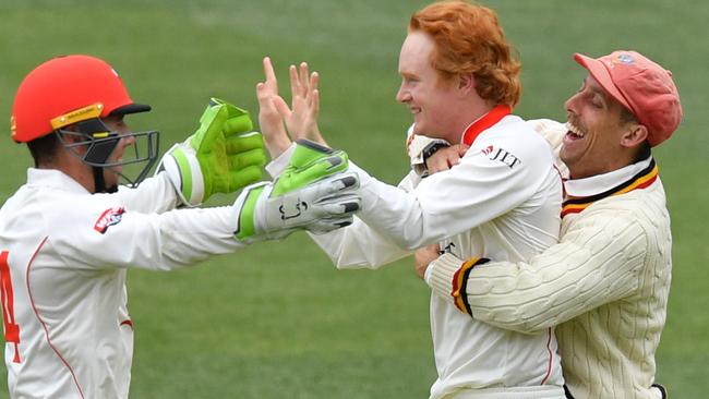 Lloyd Pope of the Redbacks (centre) celebrates with teammates Harry Nielsen (left)  and Jake Lehmann after his dismissal of Steve O'Keefe on Wednesday.