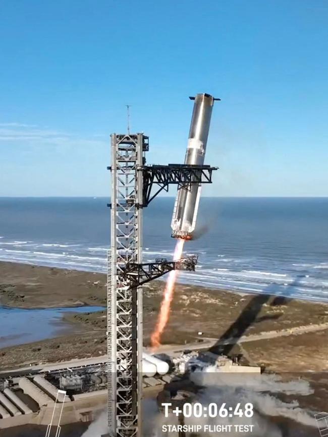 The Starship Booster is grappled mid-air as it returns to the launch pad. Picture: SpaceX / AFP