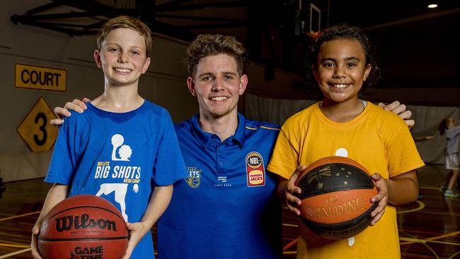 Brisbane Bullets player, Cameron Goldfinch with junior basketball players, James Hartley, 11, and Esther Taleni, 9, at the basketball school holiday camp being hosted by the North Gold Coast Seahawks. Picture: Jerad Williams