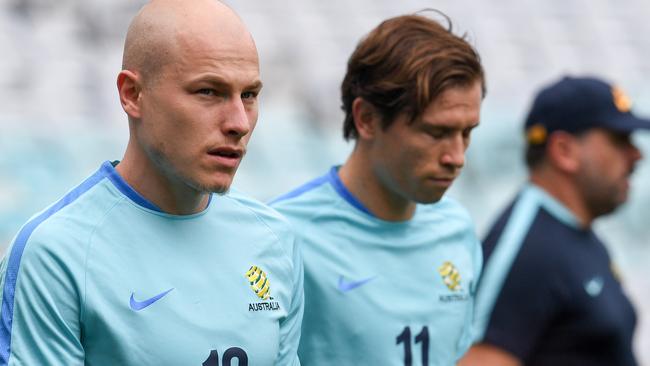 Socceroos midfielder Aaron Mooy, pictured left with Craig Goodwin, will start from the bench against Syria in Sydney tonight.