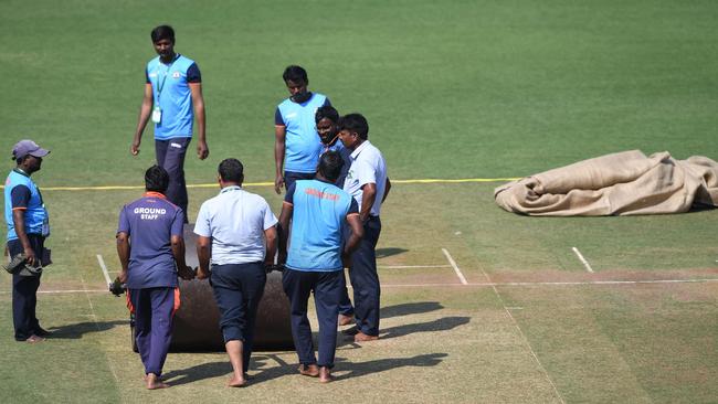 Members of ground staff use a roller on the pitch at the Vidarbha Cricket Association (VCA) Stadium in Nagpur ahead of the first Test between India and Australia. (Photo by INDRANIL MUKHERJEE / AFP)