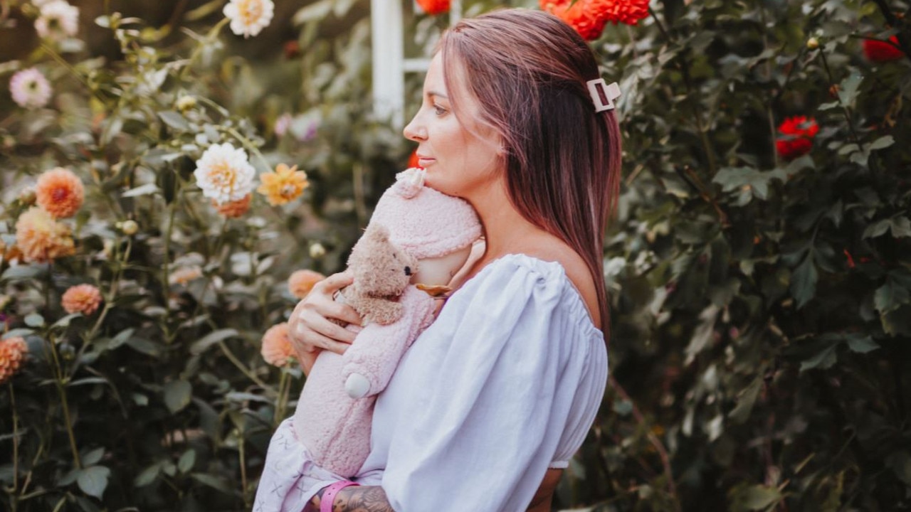 Rochelle Evrard holds her “Milli doll” that weighs the same as her daughter at birth. “Milli doll” is dressed in the pink jumpsuit. Picture: Wilde Collaborative Photography.