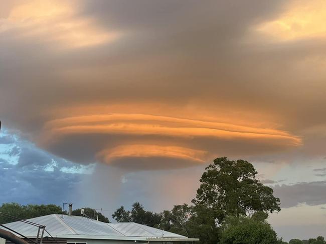 Storm that looks like a UFO over the Darling Downs in QLD. , Caption: We received several pics of this really cool UFO looking storm this morning. This is a lenticular storm cloud and its not that common to see. It occurred with a hailstorm that was moving across the Darling Downs towards Oakey and North of Toowoomba around sunrise. The sunrise helped ignite the Eastern side of the storm, turning it pink and orange. , These pics were sent into us by Bernie from Catella (5:15am), Roxanne in Meringndan looking towards Oakey and Sam from Meringandan West (5:15am), , Picture: Higgins Storm Chasing/Facebook