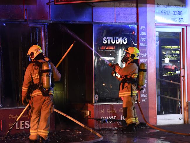 Firefighters battle the blaze at the tattoo shop in Newtown. Picture: Gordon McComiskie