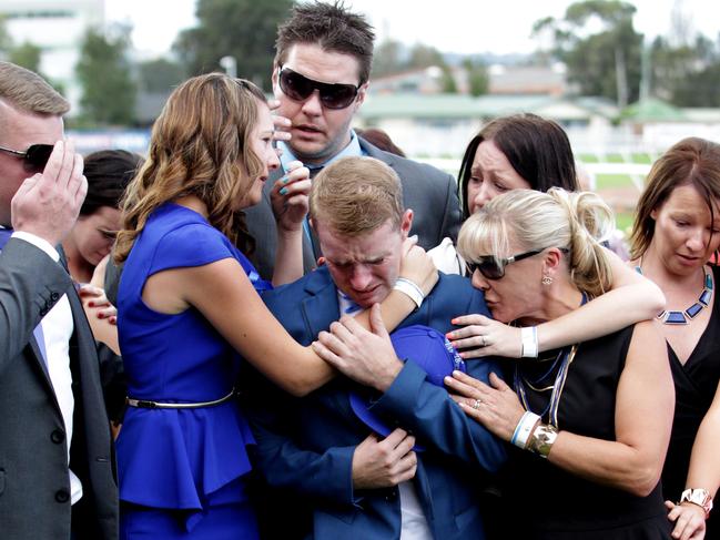 Tommy Berry is consoled by his then fiancee Sharnee Nisbet (Blue Dress) and his mum Julie Berry (Black Dress) during a tribute to Nathan Berry on Golden Slipper day in 2014.